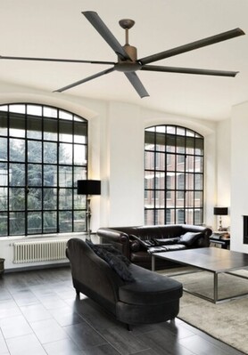 Destratificateur installé dans un séjour moderne avec canapé noir et grandes fenêtres, redistribuant l’air chaud du plafond. (destratificateur c est quoi)