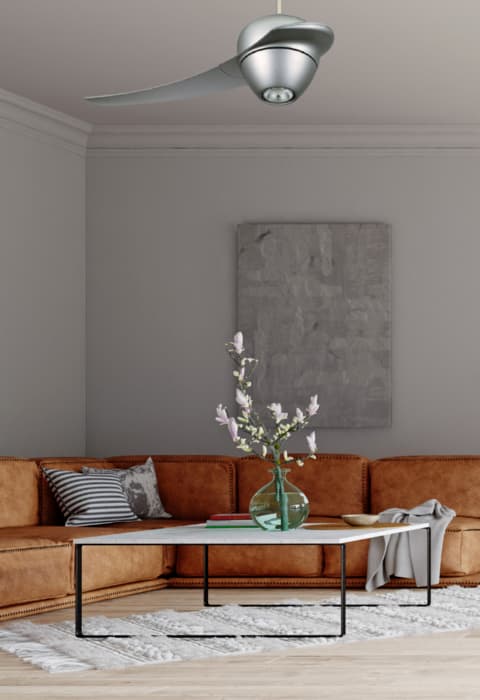 Ventilateur de plafond moderne au-dessus d’un canapé orange dans un salon, suspendu au plafond.