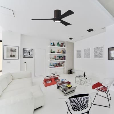 Ventilateur de plafond noir avec lampe intégré dans un salon blanc moderne.