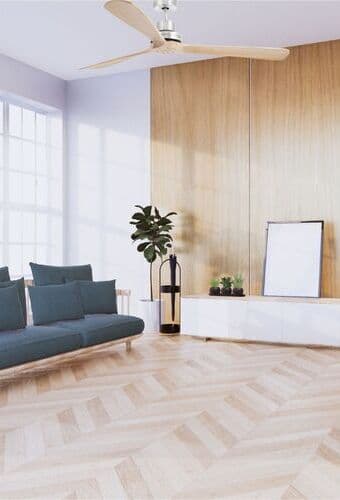 Ventilateur de plafond au plafond dans un salon moderne avec canapé et plantes, vue sur le parquet et la grande fenêtre.